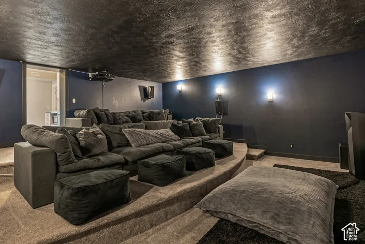 Multi-level tiered floor design featuring wall-mounted lighting, recessed ceiling texture, and carpeting