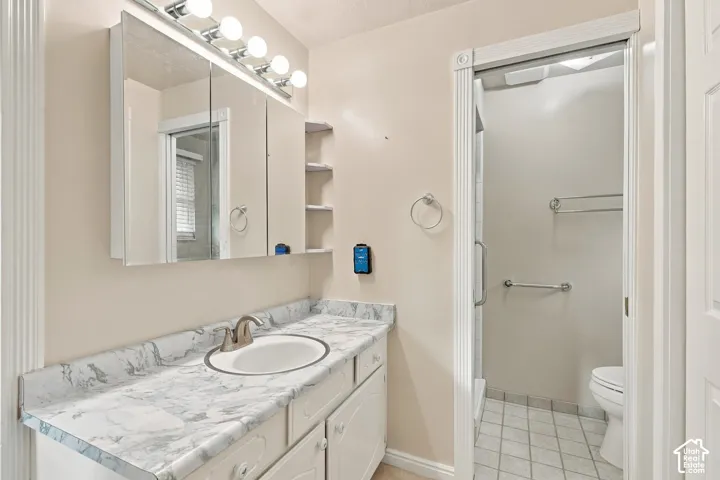 Vanity featuring a stone-patterned countertop, an integrated sink with a curved faucet, a mirrored medicine cabinet, and overhead bar lighting