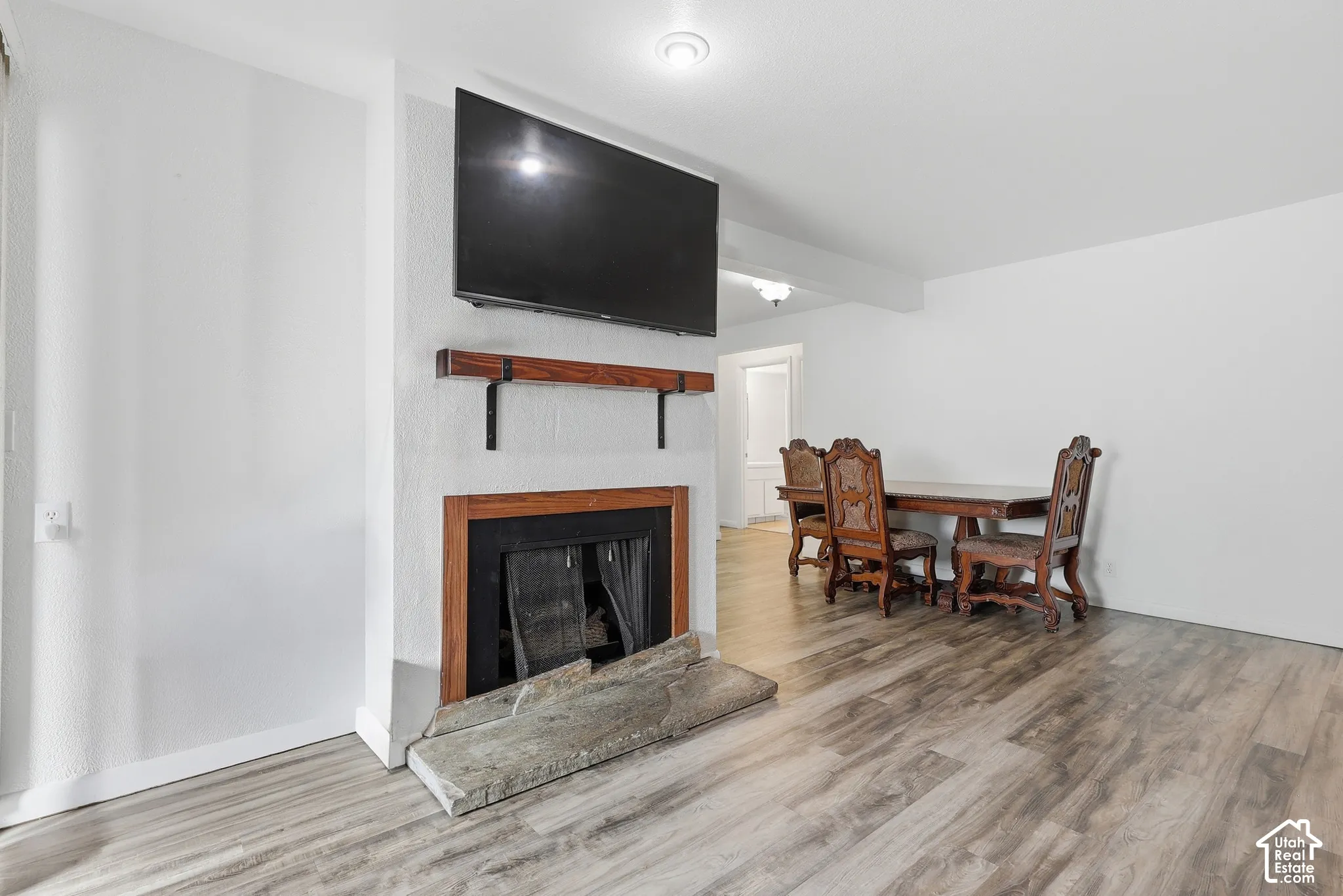 Fireplace with wooden mantel, wood-finish flooring, and recessed lighting