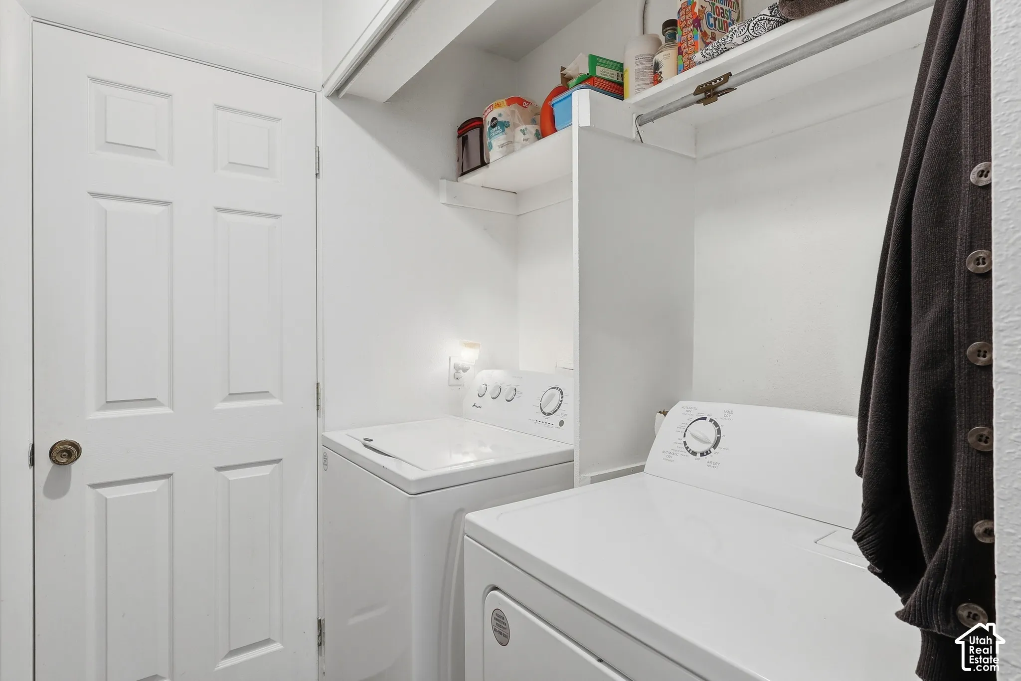 Dedicated laundry area with built-in shelving and a clothing rod