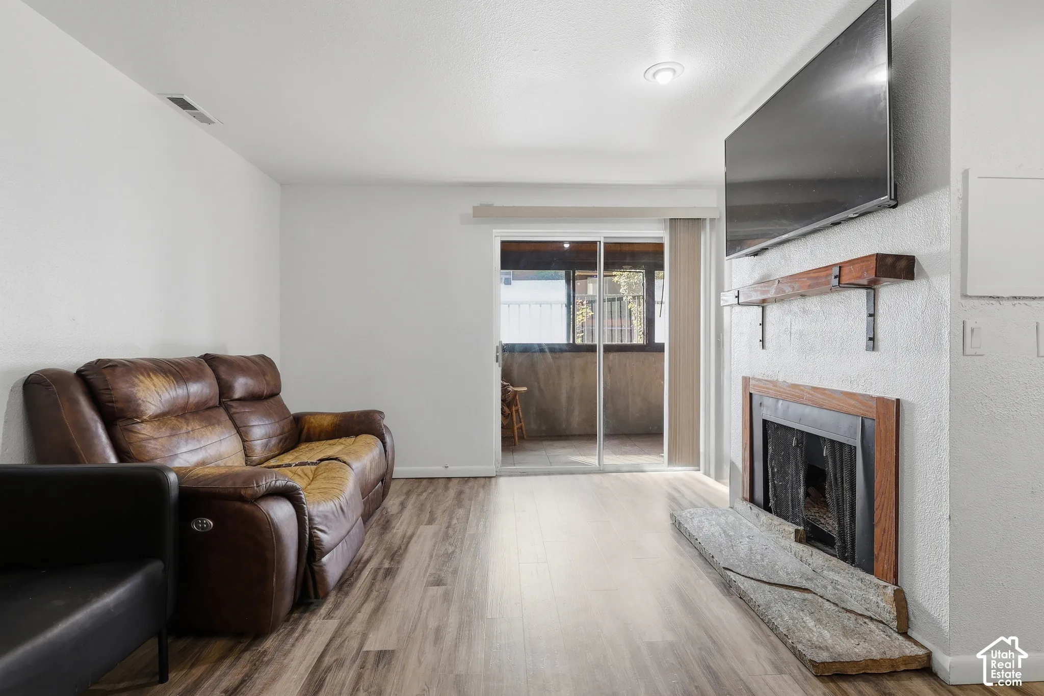 Fireplace featuring a wood mantel and stone hearth