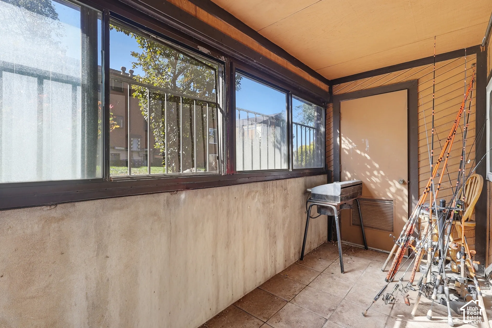 Enclosed patio with tile flooring, multi-pane windows, and a solid exterior door