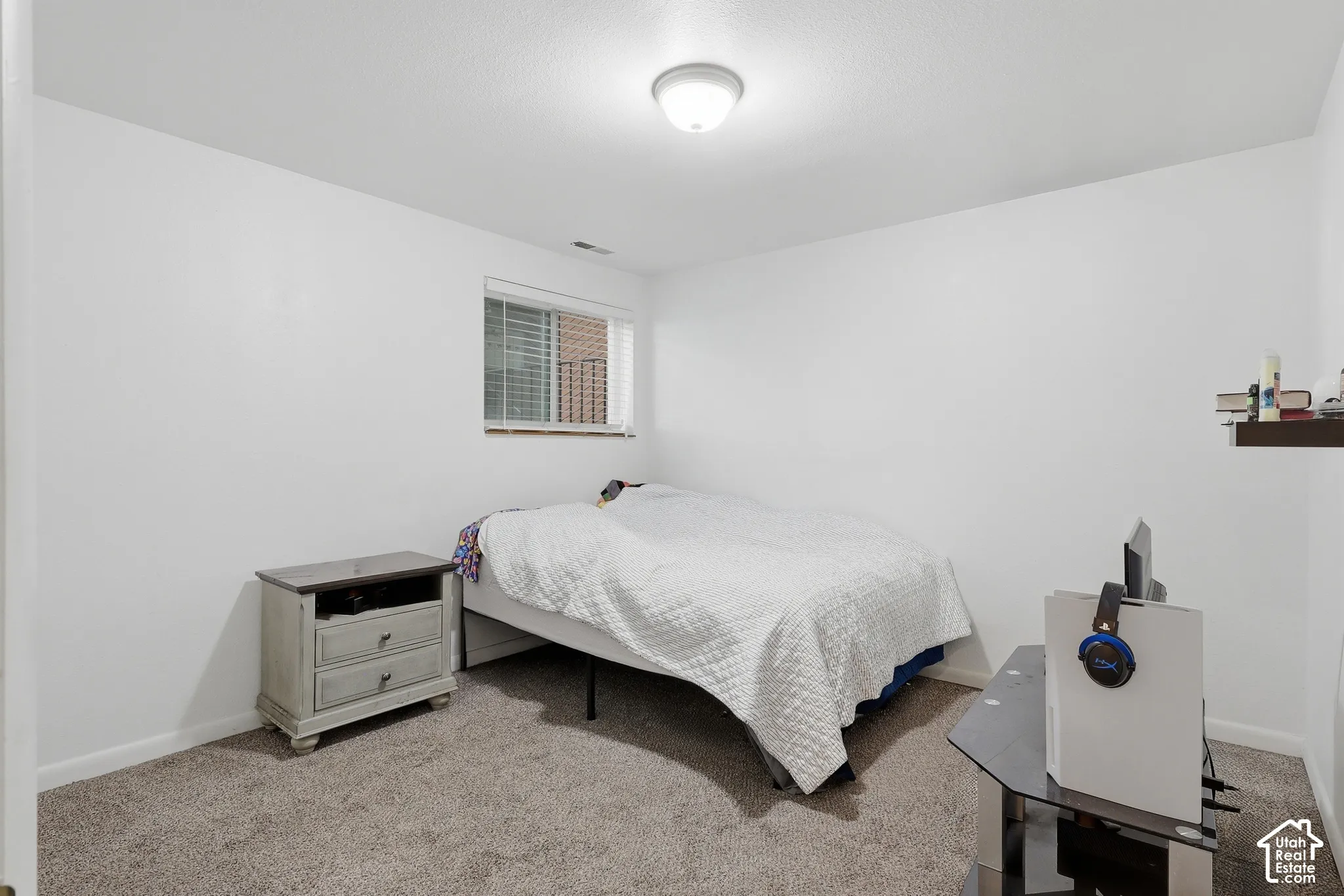 Recessed window with blinds, overhead flush mount lighting, and neutral carpeting