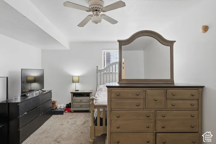 Carpeted flooring with a built-in ceiling fan and overhead lighting
