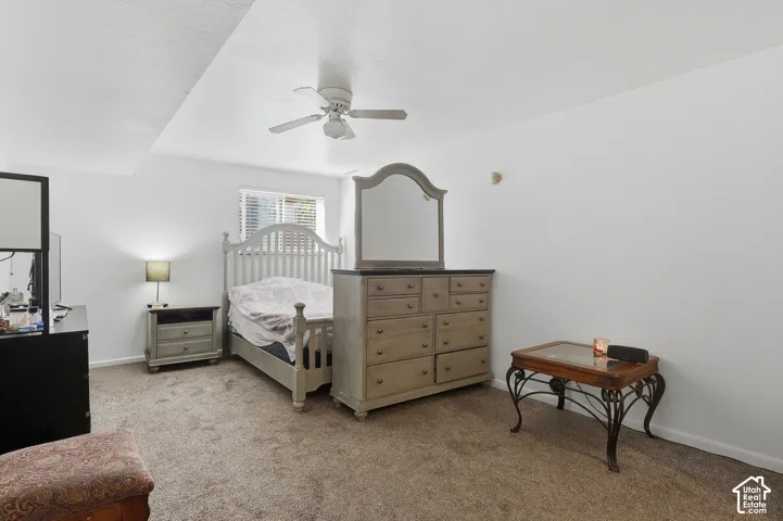 Recessed ceiling, ceiling fan, window with blinds, and carpeted flooring