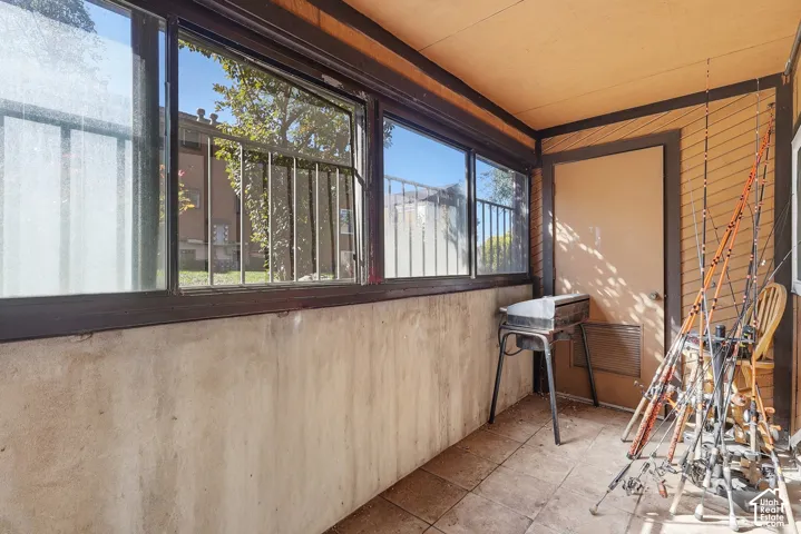 Enclosed patio with tile flooring, multi-pane windows, and a solid exterior door
