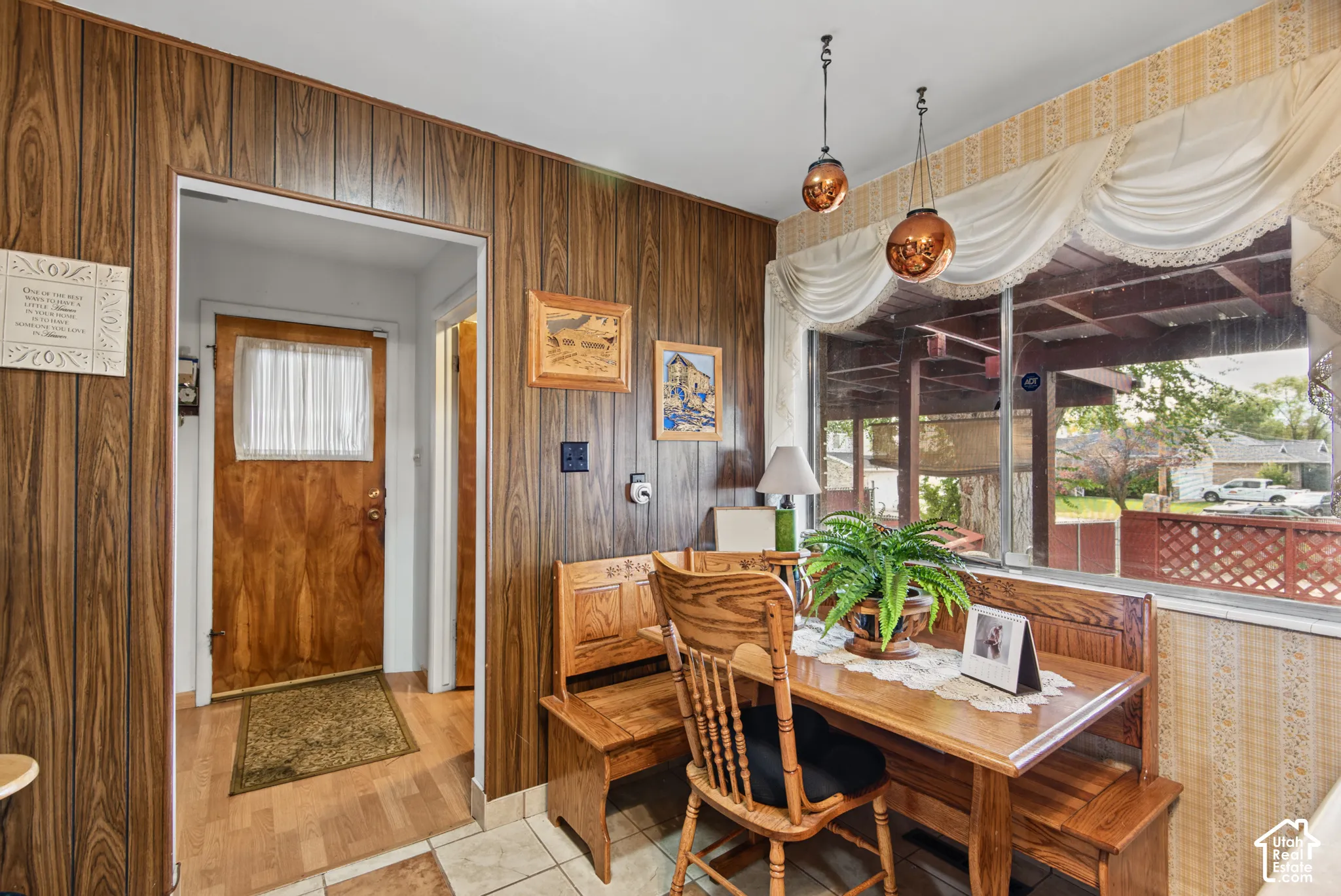 Wood-paneled walls with a large window featuring a valance