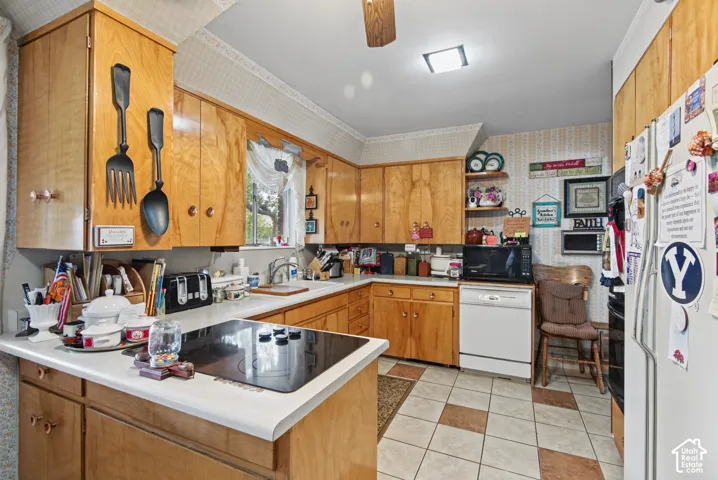 Kitchen featuring wood cabinetry, white countertops, built-in cooktop, and tile flooring