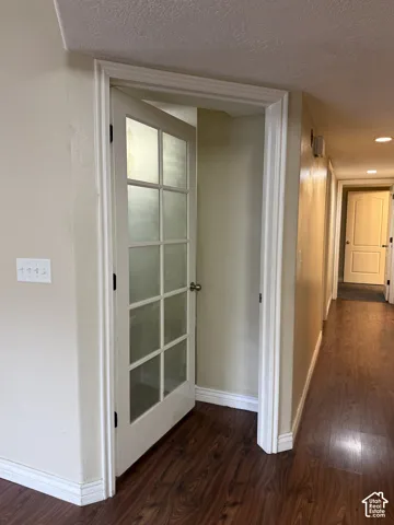 White French door with frosted glass panes, recessed lighting, and wood-finish flooring