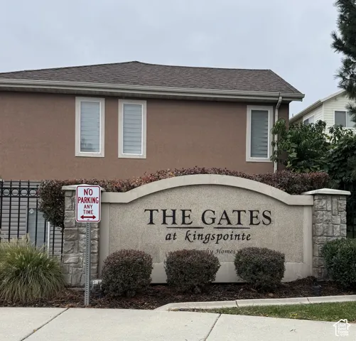 Monument signage featuring stone-clad masonry piers, stucco finish, and manicured landscaping