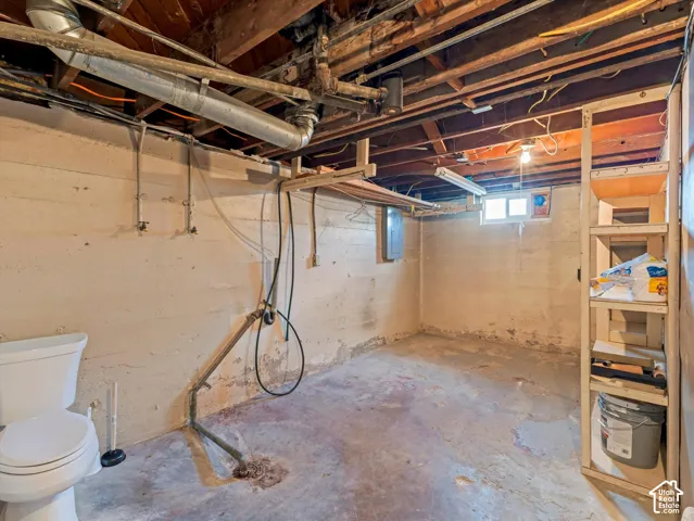 Large unfinished laundry room with toilet - plenty of room to create a full bath and separate laundry room/storage