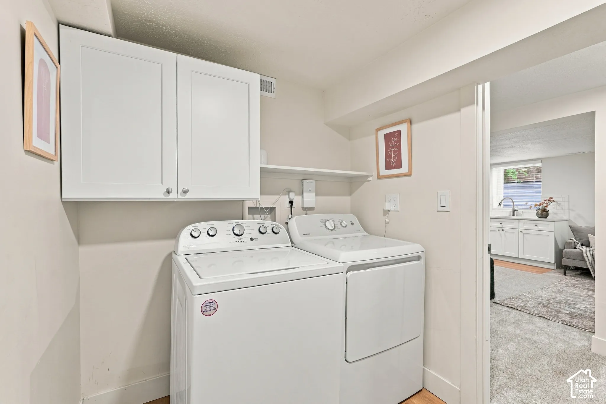 Laundry Room with cabinetry, built in shelving, hook for hanging clothes, and a closet on the opposite wall (not in photos)