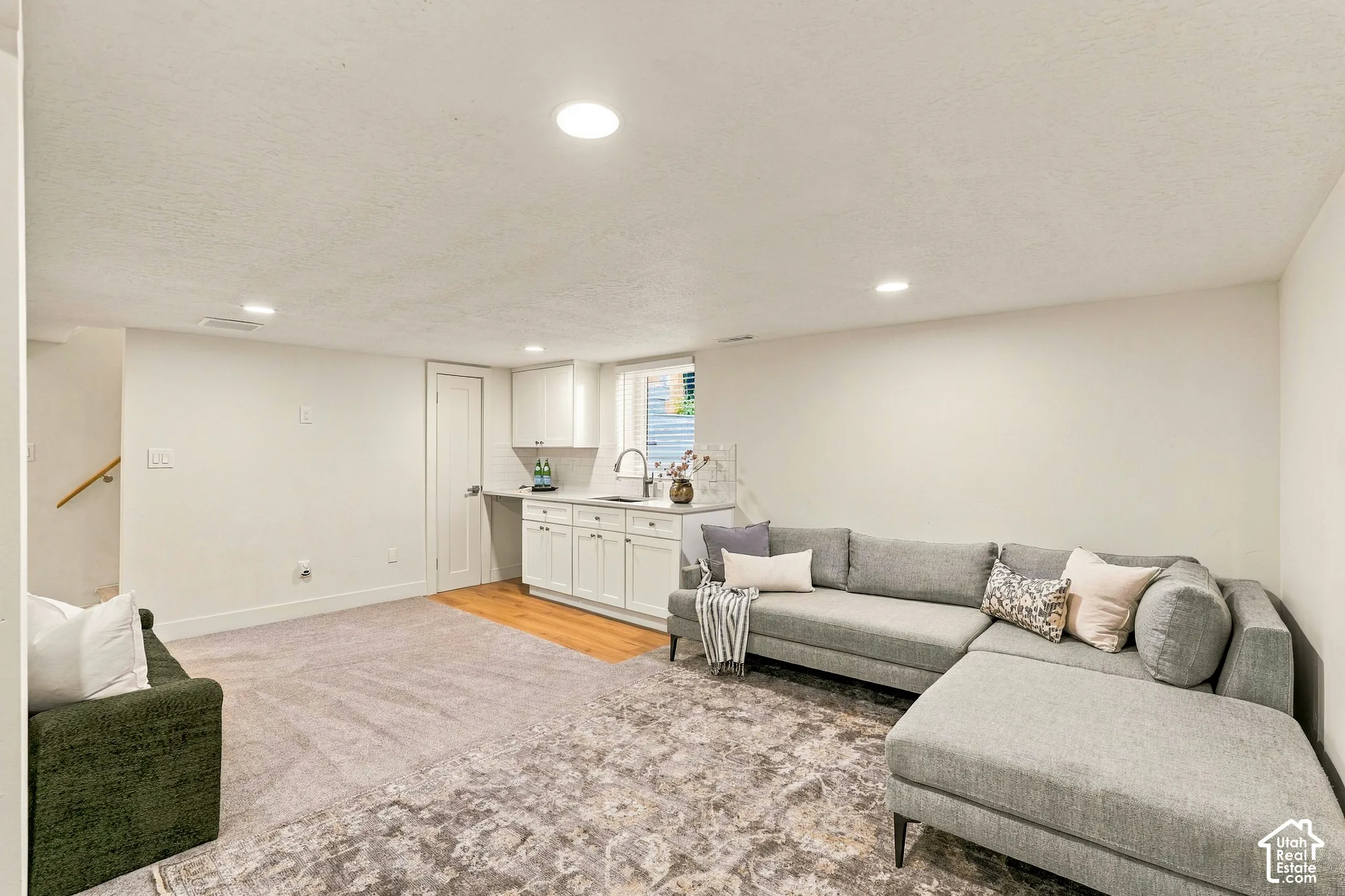 Basement Family Room with wet bar, new white shaker cabinetry and space for mini fridge, dishwasher, or stove.