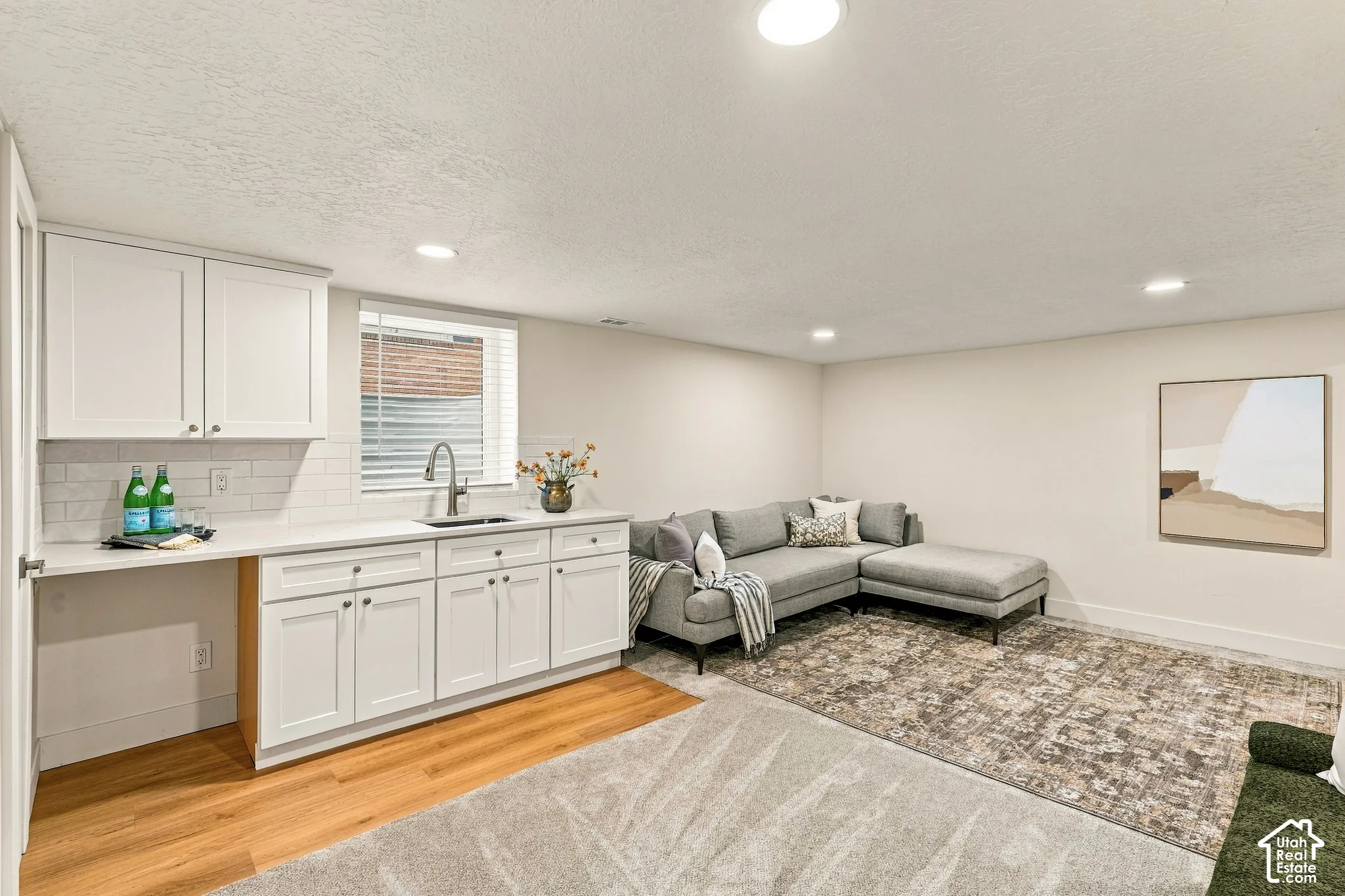 Basement Family Room with wet bar, new white shaker cabinetry and space for mini fridge, dishwasher, or stove.