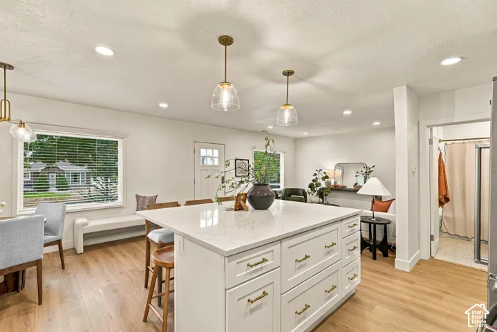 Kitchen island with a light-toned countertop and gold-finish hardware