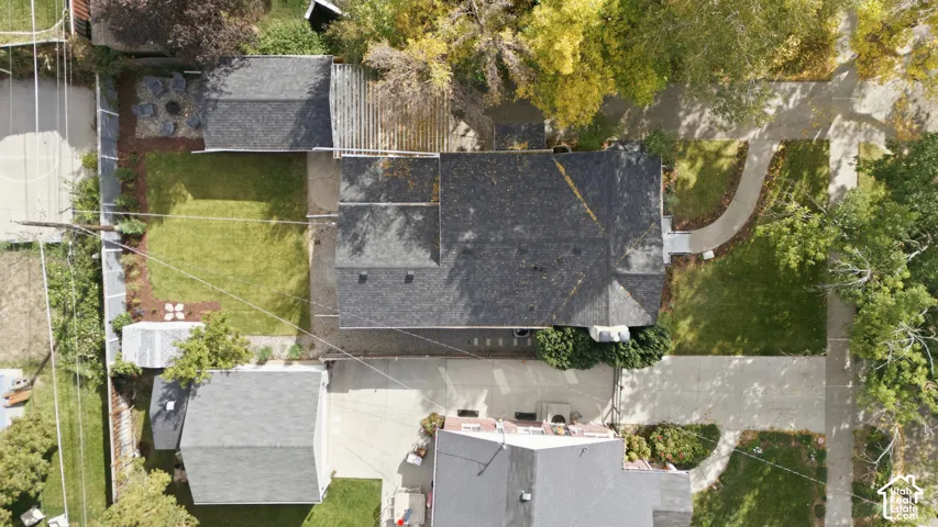 Asphalt shingle roof, paved driveway, concrete walkway, mature trees, manicured lawn