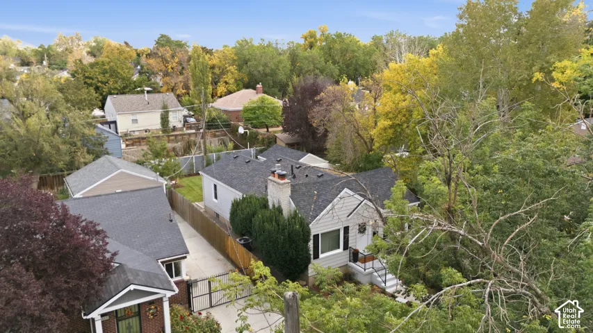 Gabled rooflines, light gray siding, dark gray shingles, white trim, and a prominent chimney
