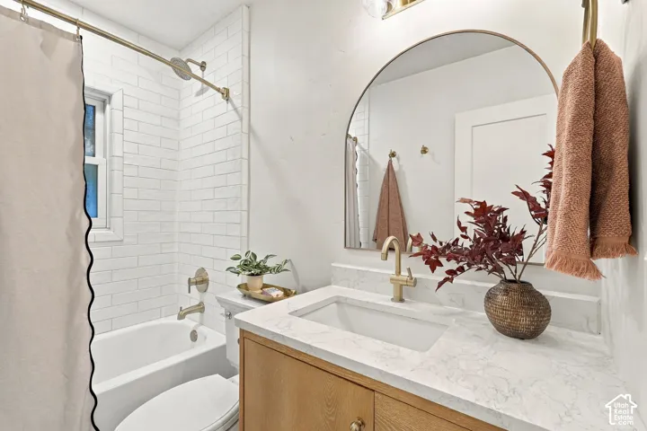 Upstairs Bathroom with blond oak vanity (with outlet inside cupboard), white subway tile, TALL gold fixtures, & marble flooring