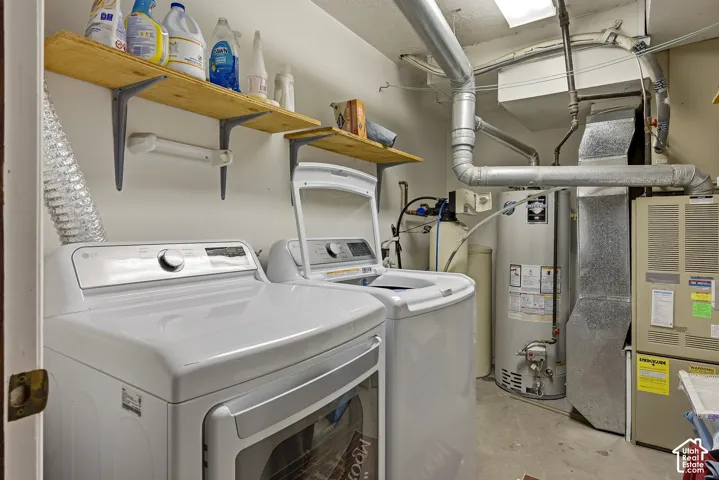 Utility space featuring wall-mounted wood shelving, a water heater, and a heating and cooling system