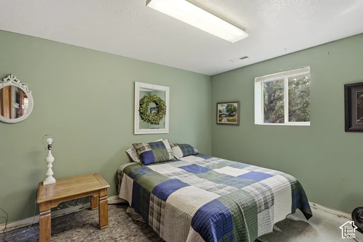 Room with neutral wall finish, rectangular window with horizontal blinds, and flush-mount linear ceiling lighting