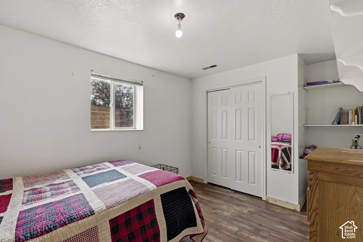 Wood-finish flooring, white paneled closet doors, built-in recessed shelving, and a dual-pane sliding window