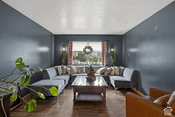 Interior space featuring wood-finish flooring, deep-toned wall finishes, and two symmetrical wall-mounted light fixtures flanking a window
