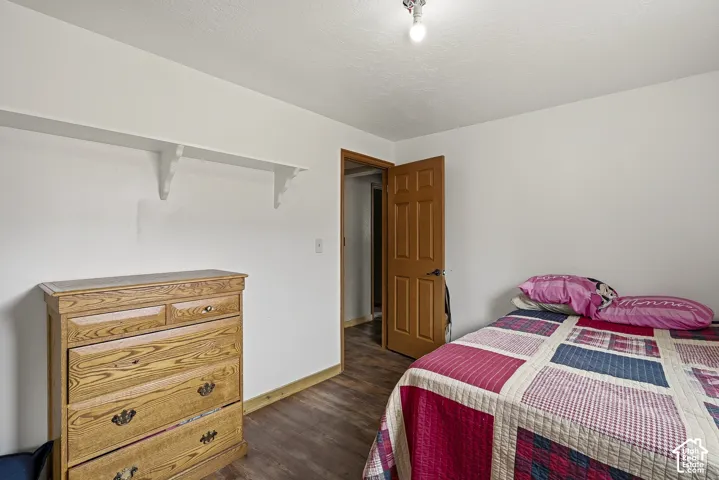 Wood-finish flooring, six-panel wood door, and wall-mounted shelving unit