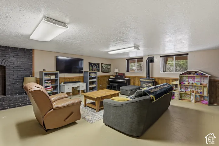 Painted brick fireplace, wood-paneled wainscoting, and freestanding wood-burning stove