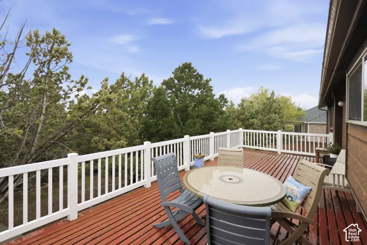 Raised exterior deck featuring red-toned wood decking and white picket-style railings