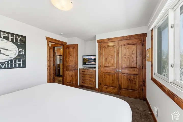 Wood-finish doors and trim, built-in cabinetry with a stone-finish countertop, and a window providing natural illumination