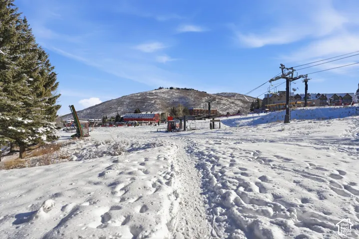 Ski-in/ski-out access featuring direct proximity to chairlift infrastructure, mature conifer trees, and mountainous terrain