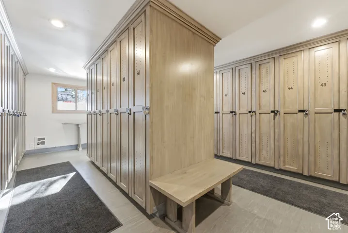 Built-in wood-finish lockers with integrated bench seating, recessed lighting, and a single window