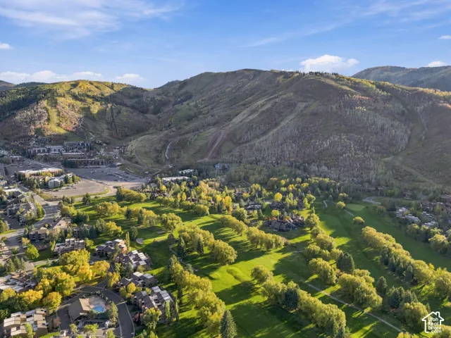 Aerial perspective showcasing a mountain landscape, golf course, and residential structures