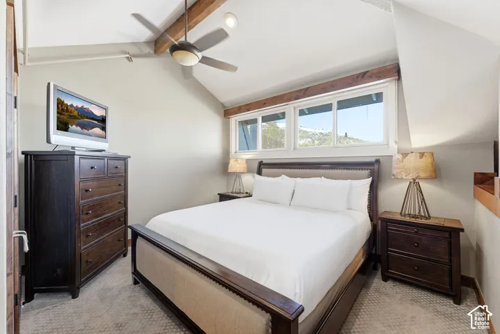 Vaulted ceiling with exposed wood beam, recessed lighting, ceiling fan, and large horizontal sliding windows