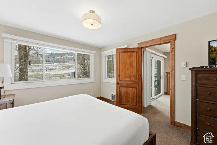 Wood-finish door and trim, carpeted flooring, and a semi-flush mount ceiling light
