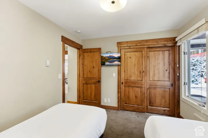 Wood-finish interior door and trim, wood-finish sliding closet doors, ceiling-mounted light fixture, and a window with a roll-up shade