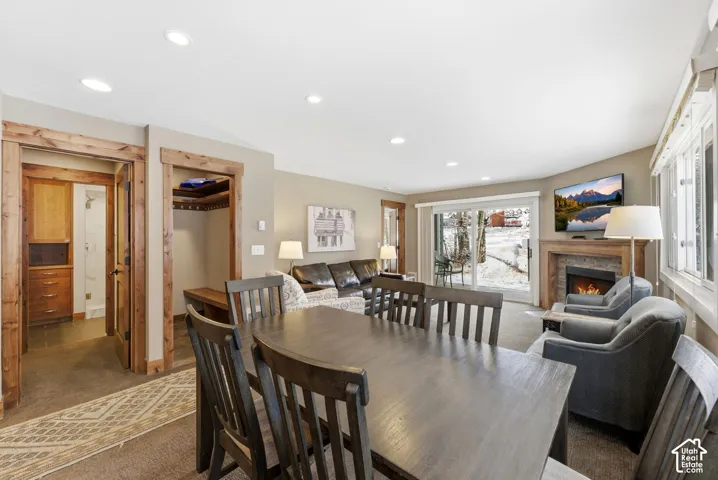 Recessed lighting, wood-finish trim, stone-clad fireplace, and sliding glass door