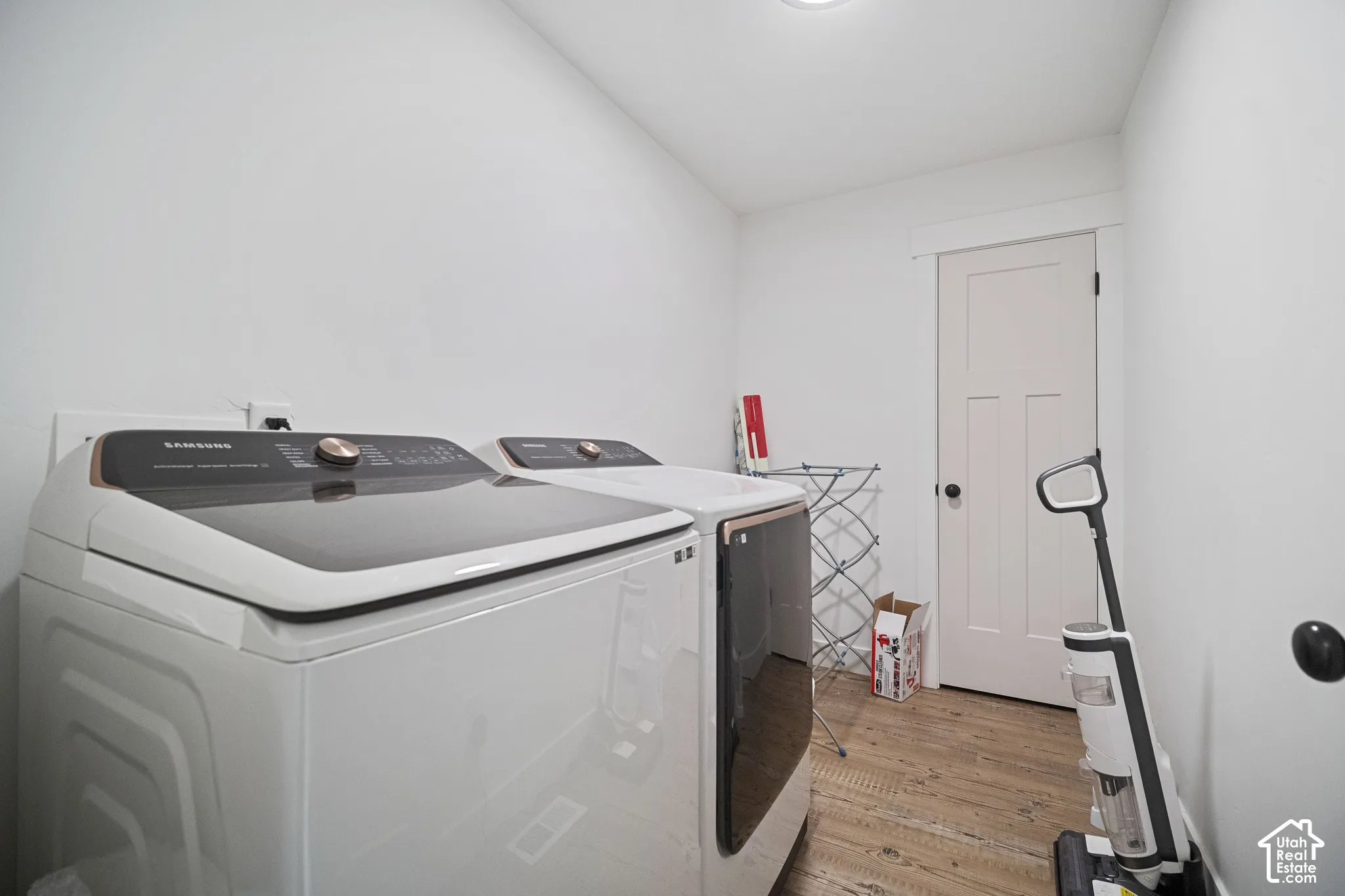 Laundry space featuring wood-finish flooring and a craftsman-style interior door