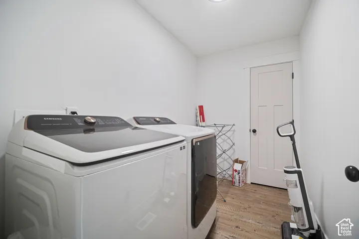 Laundry space featuring wood-finish flooring and a craftsman-style interior door