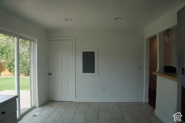Sliding glass door, light-toned tile flooring, recessed ceiling lighting, and a six-panel interior door