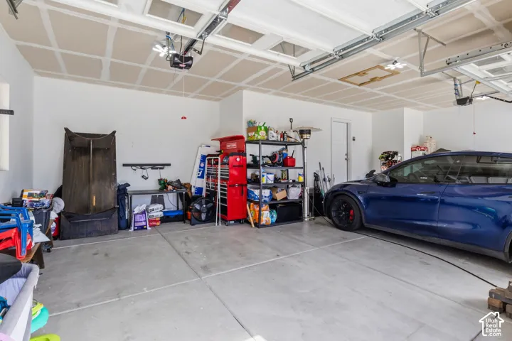 3 car garage featuring a concrete floor, 240-volt charger for electric vehicles.