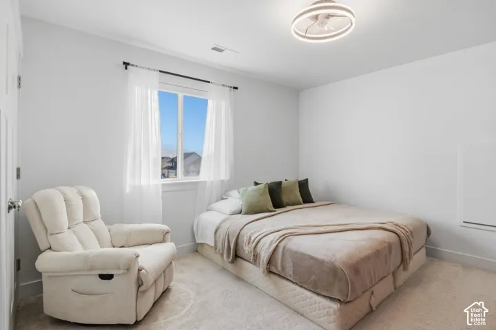 4th bedroom carpeted and a modern circular LED light fixture with an integrated fan