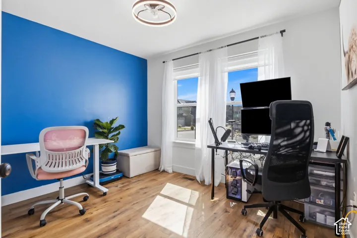2nd Bedroom or Office space -Wood-finish flooring, accent wall, and ceiling-mounted light fixture featuring dual windows with curtain rods