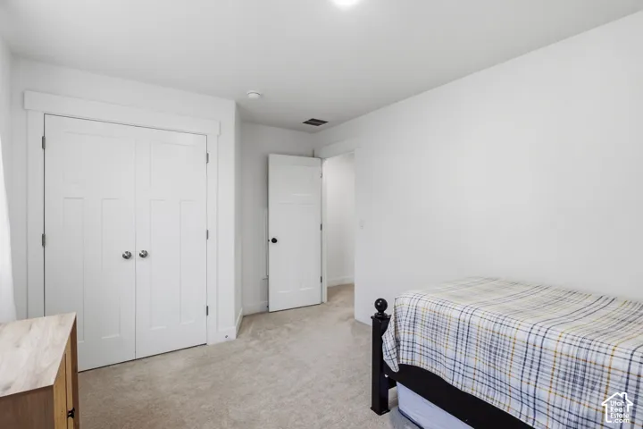 5th Bedroom Neutral-toned wall-to-wall carpeting, white four-panel interior doors, and custom-trimmed door casing