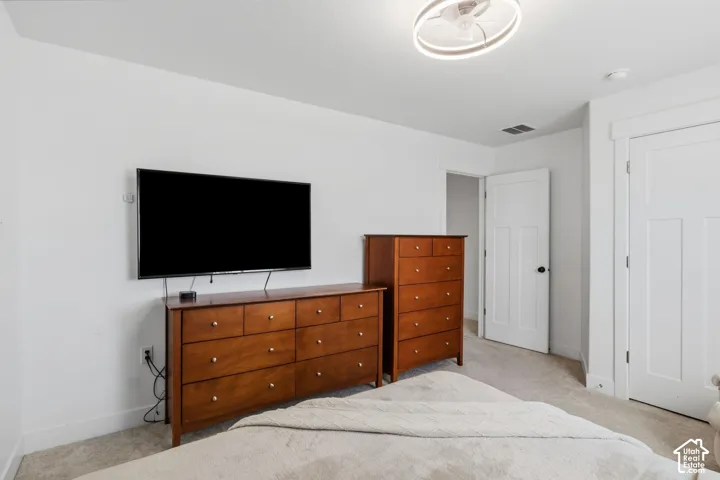4th bedroom carpeted and a modern circular LED Light fixture with an intergrated fan
