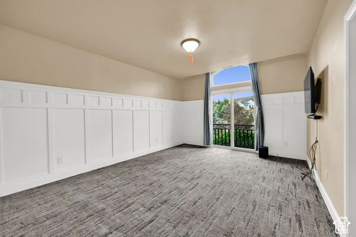 Room featuring wall-to-wall carpeting, wainscoting,  and exterior balcony