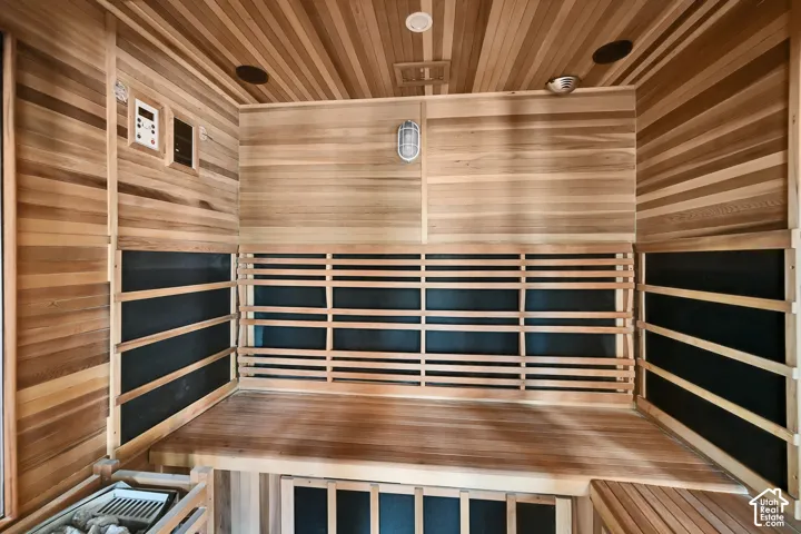 Sauna featuring natural wood tongue-and-groove paneling, tiered wood bench seating, use as either traditional or infrared.