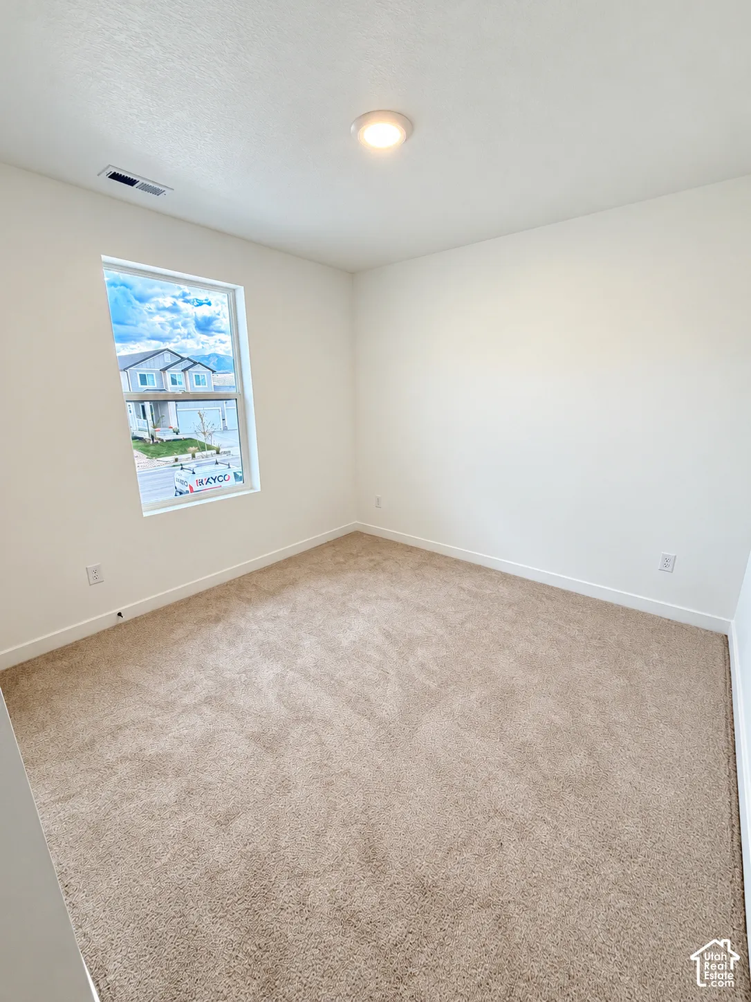 Neutral interior featuring neutral-toned carpeting, off-white walls, and a recessed ceiling light