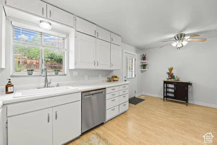 Kitchen featuring white cabinetry, wood-finish flooring, stainless steel dishwasher, farmhouse-style sink with a gooseneck faucet, and a ceiling fan