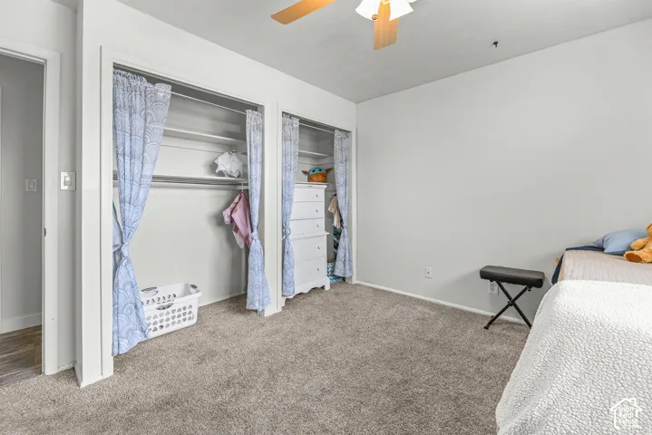 Room interior featuring neutral wall paint, wall-to-wall carpeting, and a ceiling fan with integrated lighting